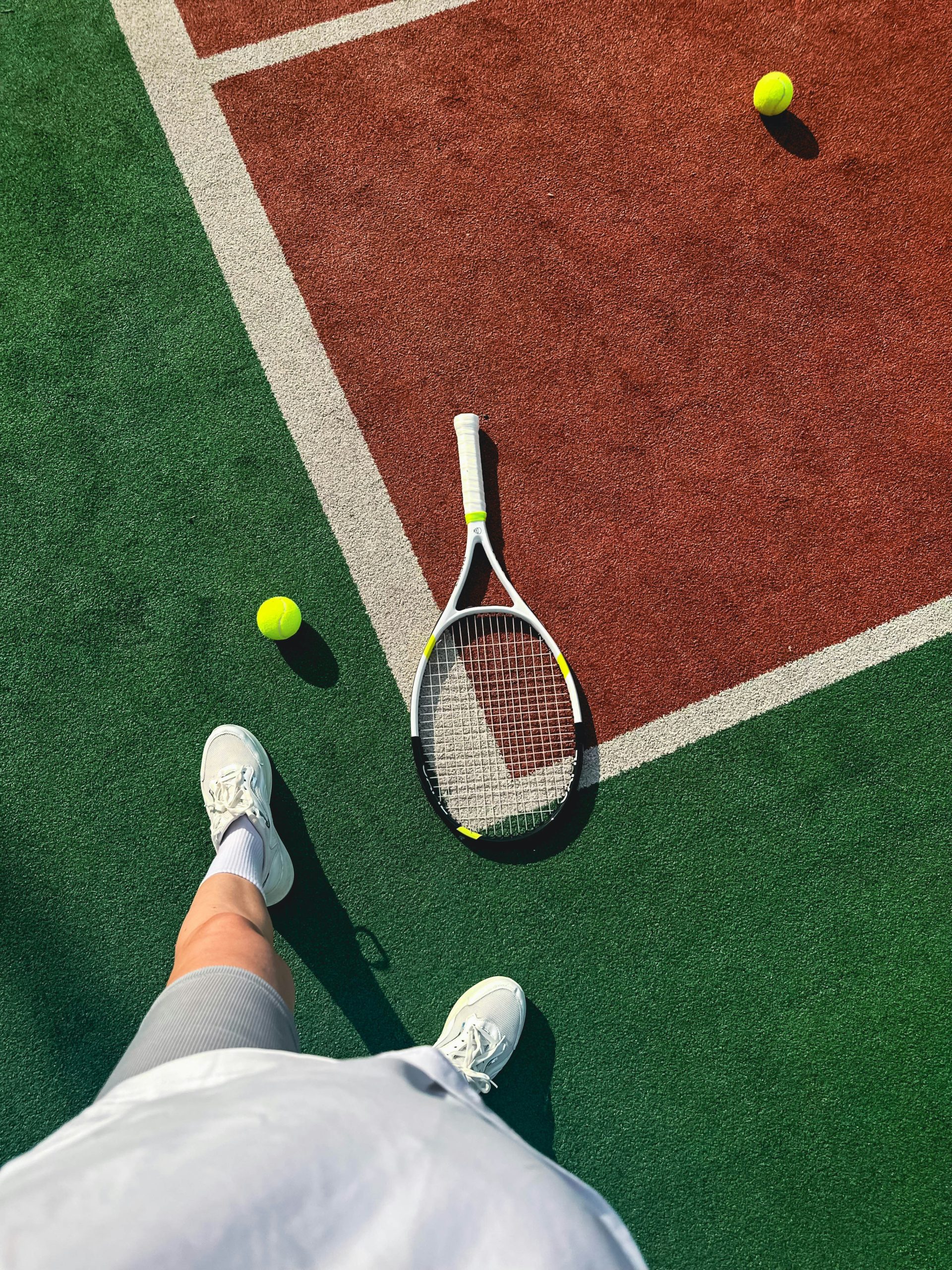 A person standing on a tennis court holding a racquet